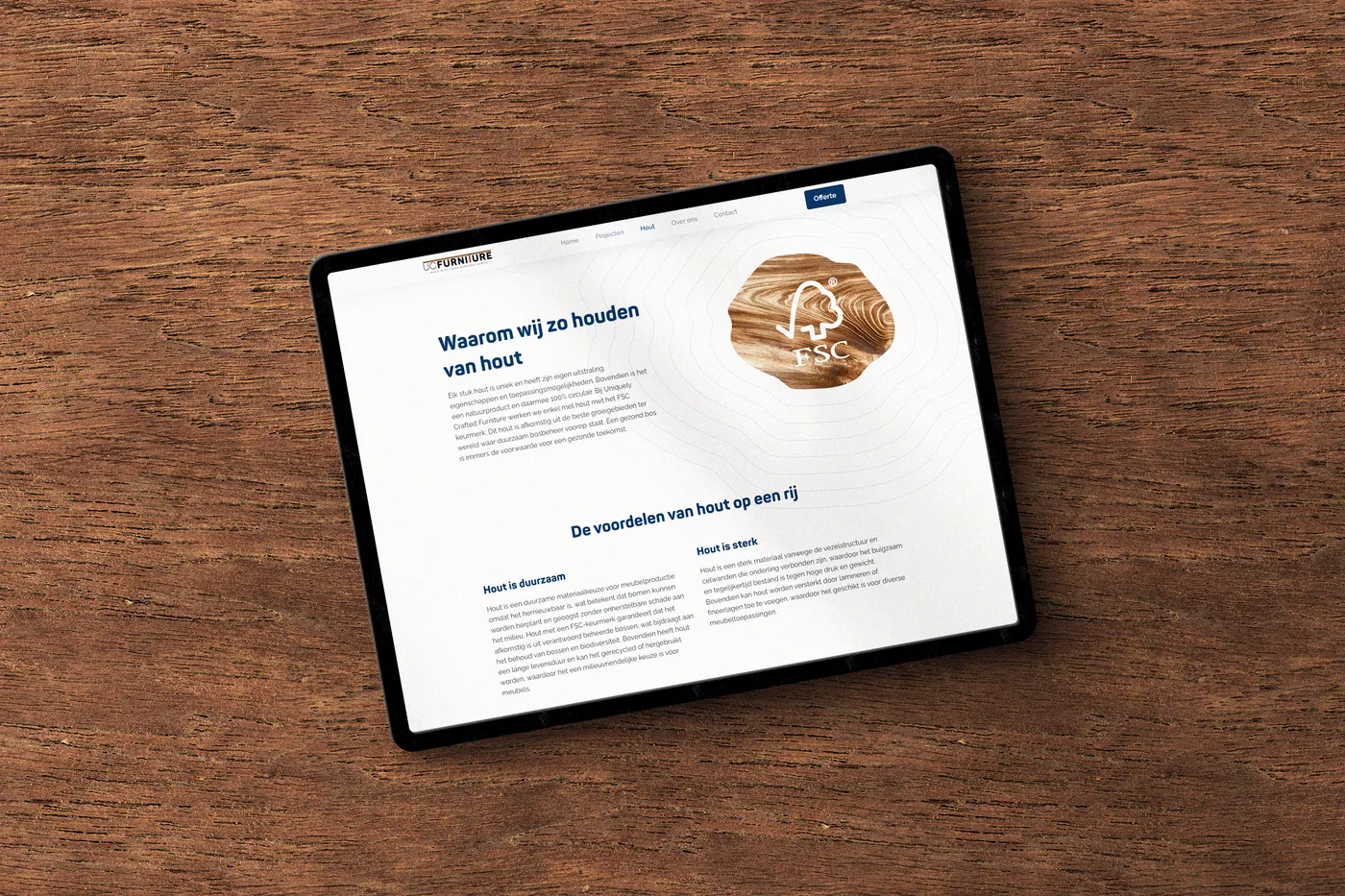 Tablet op houten blad met een pagina over houtgebruik bij UCFurniture